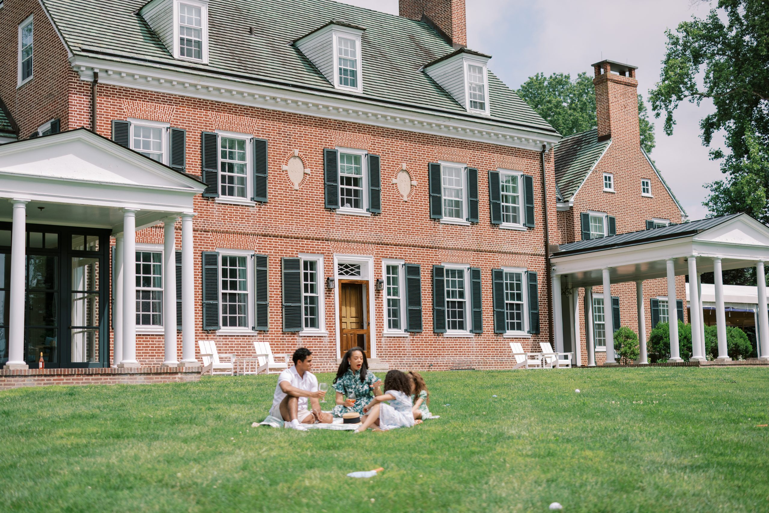 A photo of a family picnicking in front of The Manor House at Bohemia Manor Farm